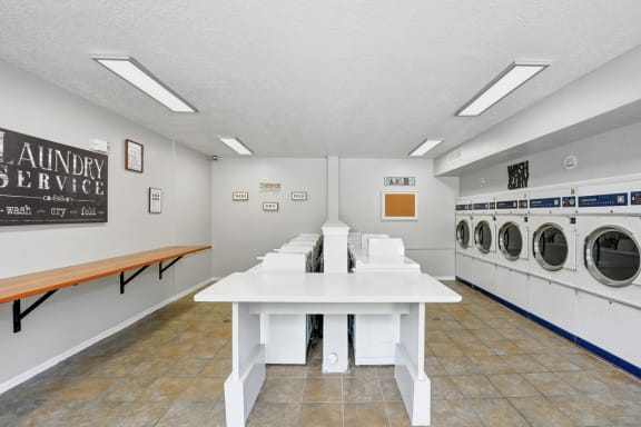 a laundry room with tables and washers and dryers