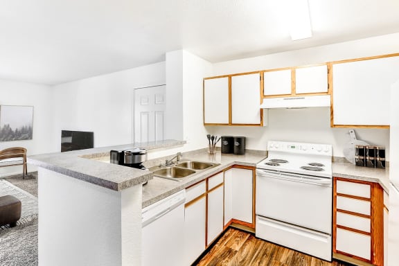 Model Kitchen with White Appliances, Grey Counters and White Cabinets with Wood Accents