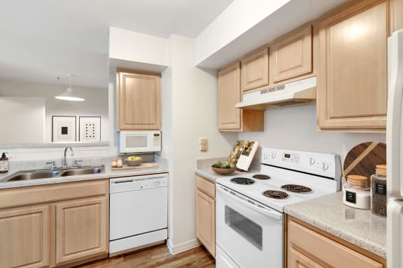 a kitchen with wooden cabinets and white appliances