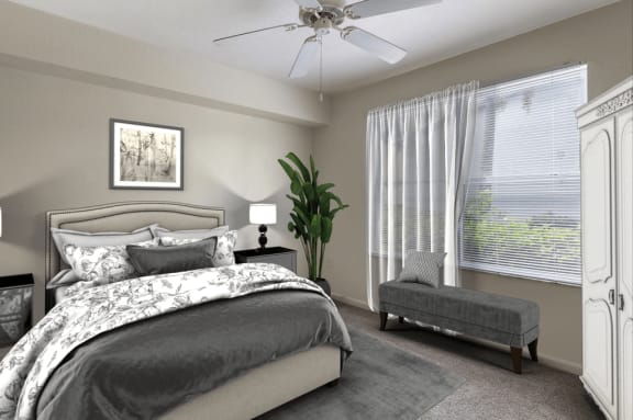 Virtually staged bedroom with tan carpeted flooring, arge window with white blinds and a white multi-speed ceiling fan