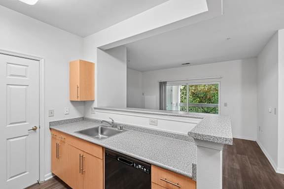 A kitchen with a white counter top and wooden cabinets.