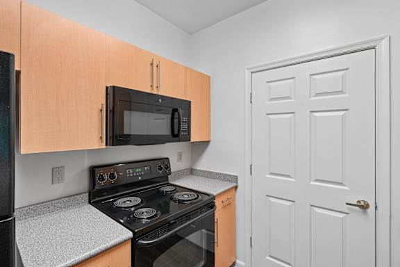A kitchen with a black stove and microwave.