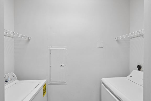 A white laundry room with a washer and dryer.