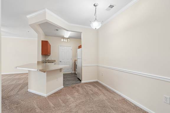 A room with a kitchenette and a doorway leading to another room.