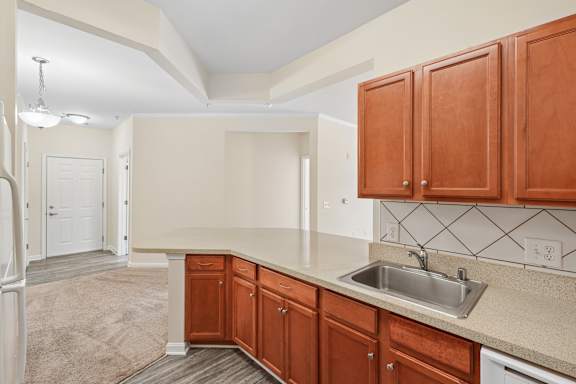 A kitchen with brown cabinets and a white sink.