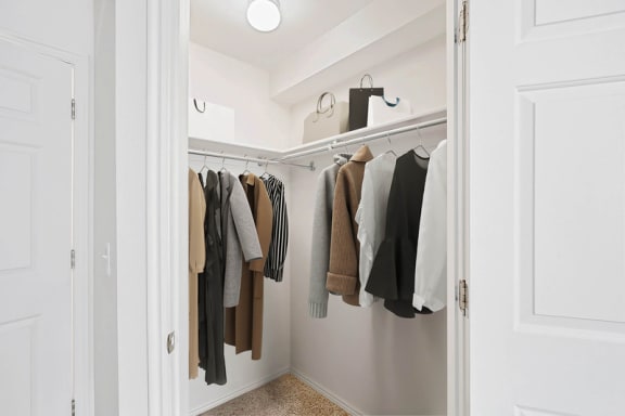 Walk-in closet with corner hanging rods at Rose Cove Homes Apartments, Utah
