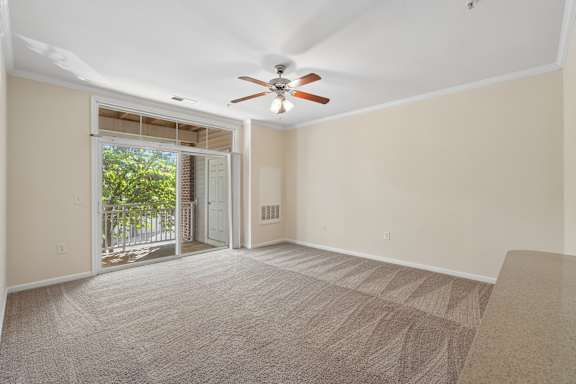 A room with a carpeted floor and a ceiling fan.