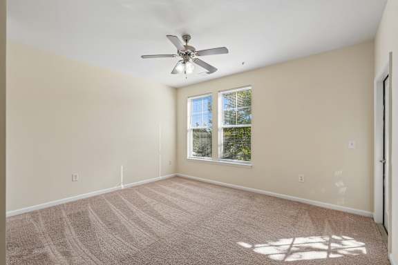 A room with a ceiling fan and a window.