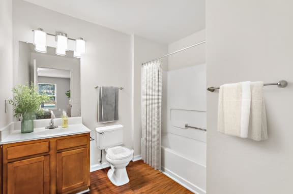 a bathroom with a white toilet next to a bathtub with a shower curtain