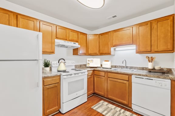 a kitchen with white appliances and wooden cabinets