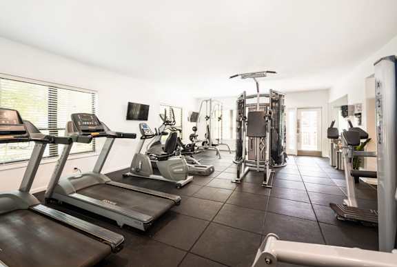 A spacious gym with treadmills, exercise bikes, and other equipment.