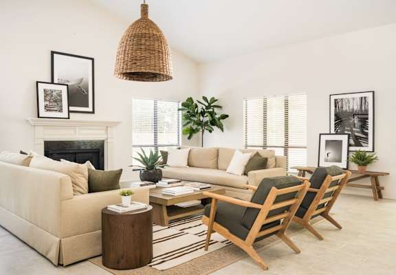 A living room with a fireplace, couches, and a rug.