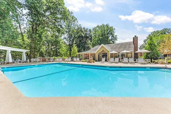 A large swimming pool in front of a house.