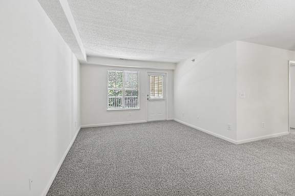 A room with a carpeted floor and a window.