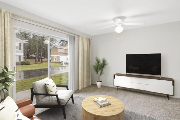 Living room area facing exterior sliding glass door with a couch and television