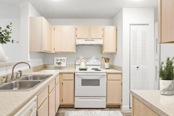 a kitchen with white appliances and wooden cabinets