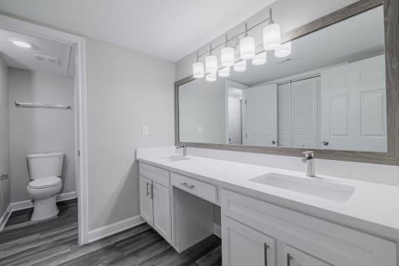 a bathroom with dual vanities, white countertops and cabinetrty