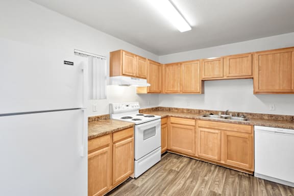 a kitchen with wooden cabinets and white appliances