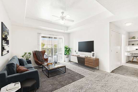 A living room with a grey sofa, a black TV, and a glass coffee table.