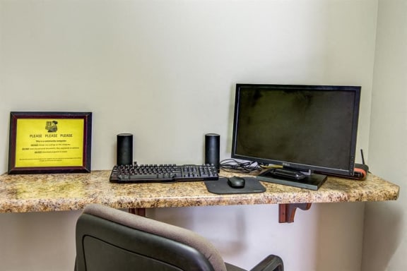 Business Center with Computer Next to Keyboard and Speakers Next to Yellow Sign