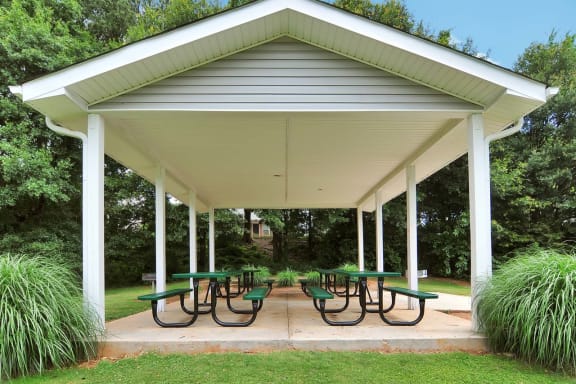 a pavilion with picnic tables in a park