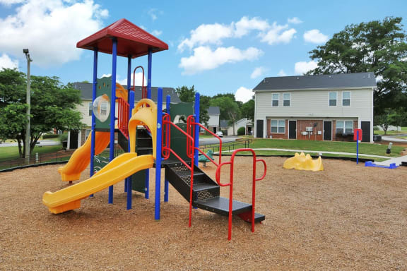 a playground with a yellow and red slide and monkey bars