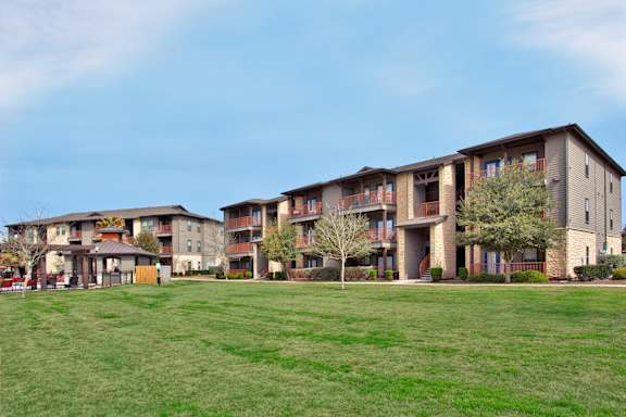 Apartment complex with a green lawn in front.