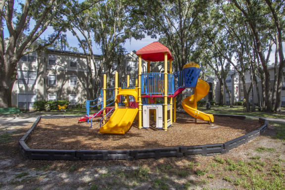 a playground with a yellow slide and a red and blue slide