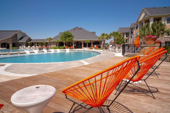a swimming pool with orange chairs