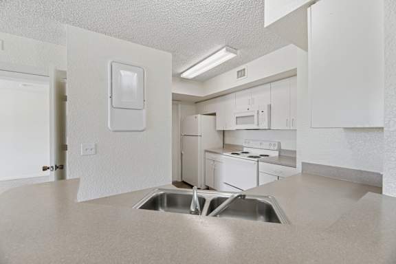 A kitchen with white appliances and cabinets.
