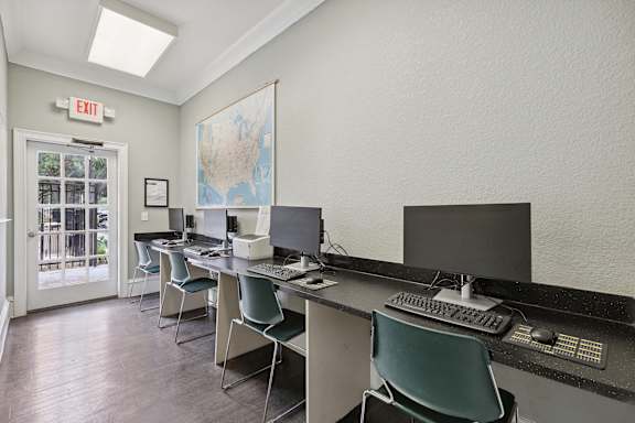 A room with a map of the United States on the wall and a red exit sign above the door.