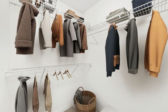 a wardrobe of coats and jackets hanging on a white wall