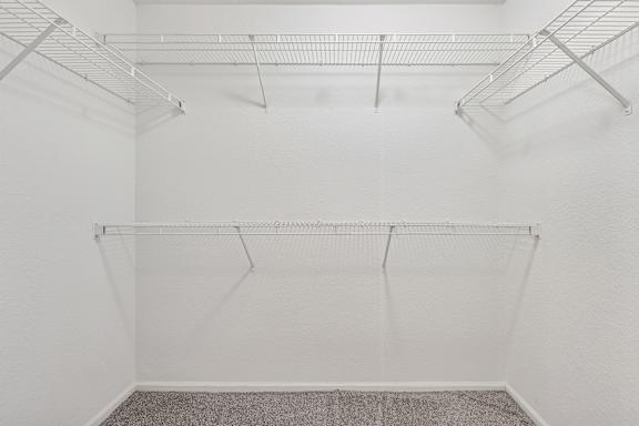 Empty room with white walls and a grey carpet.