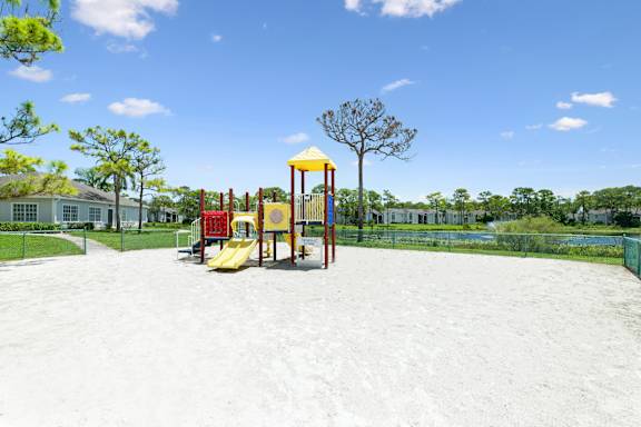 A playground with a yellow slide and a red and yellow play structure.