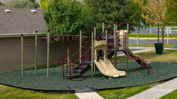 A playground with a slide and a climbing frame.