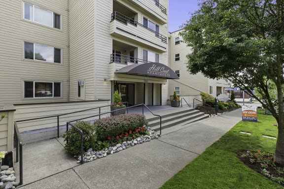 a view of the front of the building with the steps leading up to the entrance at Hill Crest Apartment Homes, WA 98126
