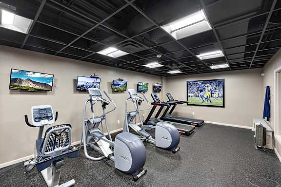 A gym with a row of exercise bikes and treadmills at MainCentre, Northville