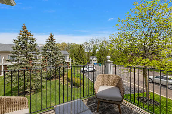 A chair is on a table on a balcony overlooking a street.