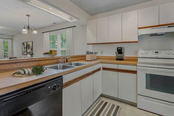 a kitchen with white cabinets and a sink and a dishwasher at Hunter's Ridge Apartments, Fayetteville, NC, 28305