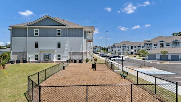 A large grey house with a black fence in front.