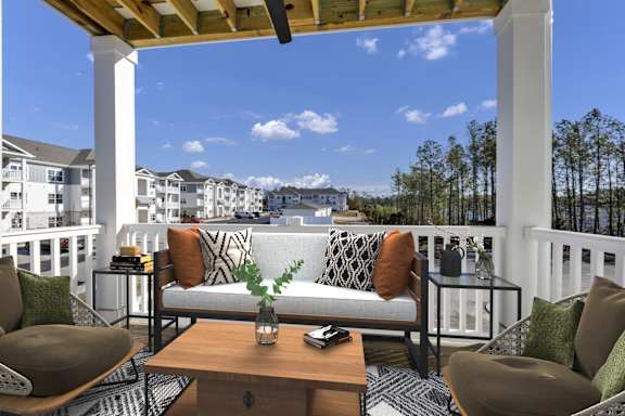 A patio with a white couch and a wooden table.