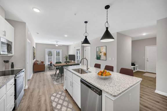 A modern kitchen with a granite countertop and stainless steel appliances.