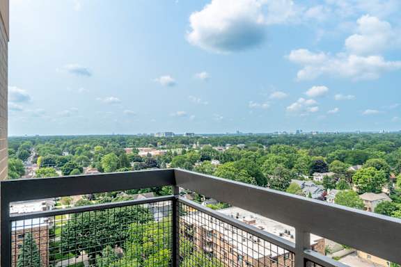 A balcony overlooks a lush green landscape.