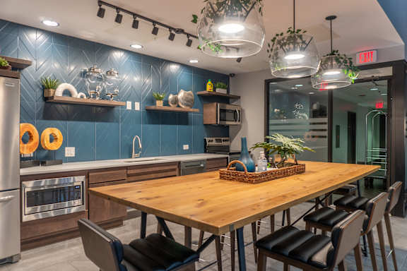 A modern kitchen with a wooden table and chairs.