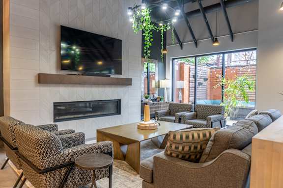 A living room with a fireplace and a television mounted above it.