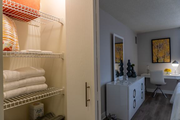 A bathroom with a white chair and a white cabinet.
