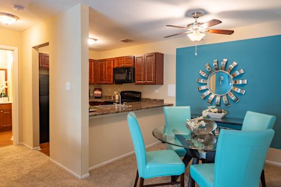A kitchen with a table and chairs.