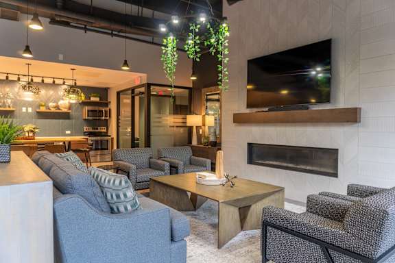 A modern living room with a grey sofa and a fireplace.