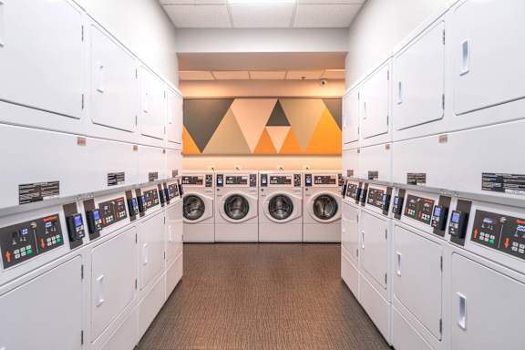 A row of washing machines are lined up in a laundromat.