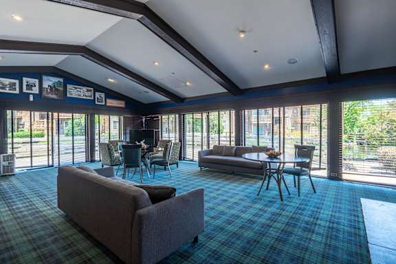 A large room with a couch, chairs, and a dining table.